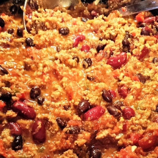 A close up of Tex-Mex Turkey Chili with a silver serving spoon in the dish
