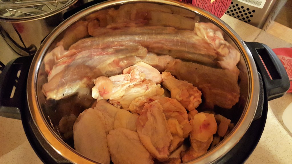 An Instant Pot with raw chicken wings in it.