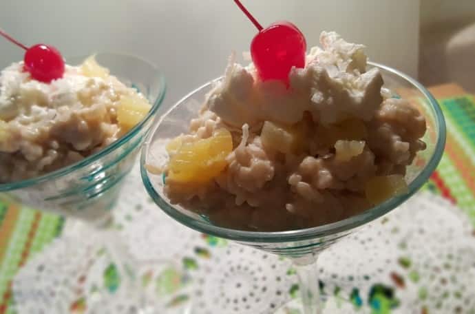 A bowl of Pressure Cooker Piña Colada Rice Pudding with a cherry on top