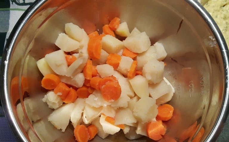 A bowl filled with potatoes and carrots