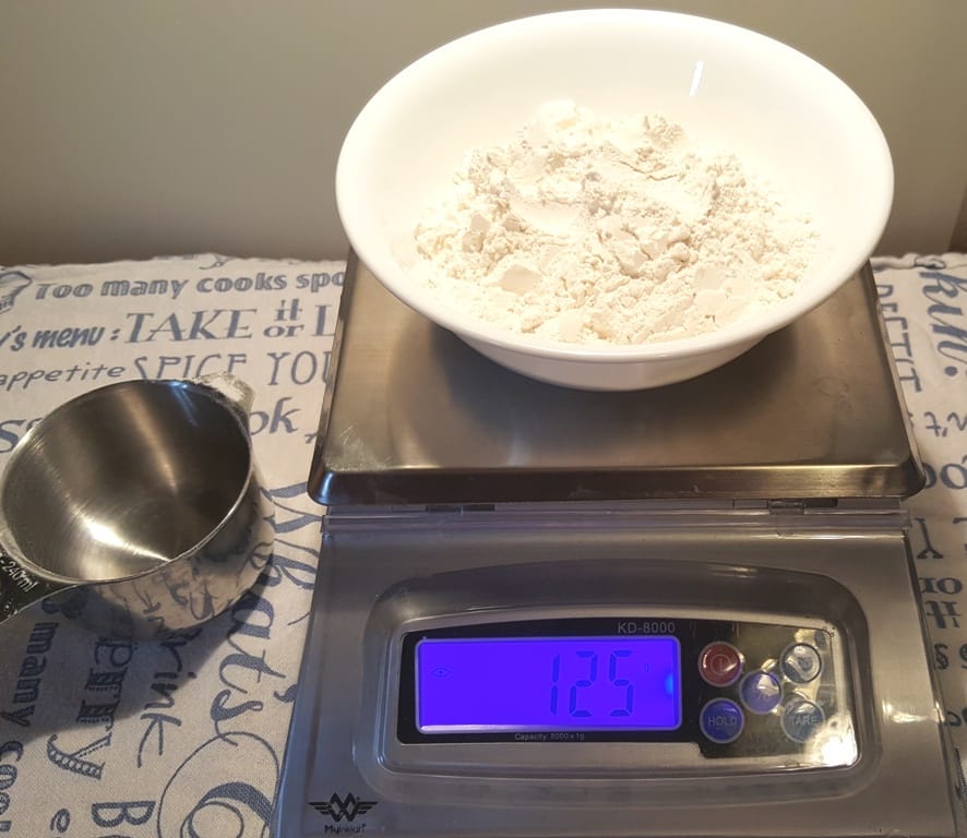 Measuring Flour Into Kitchen Scales Stock Photo, Picture and