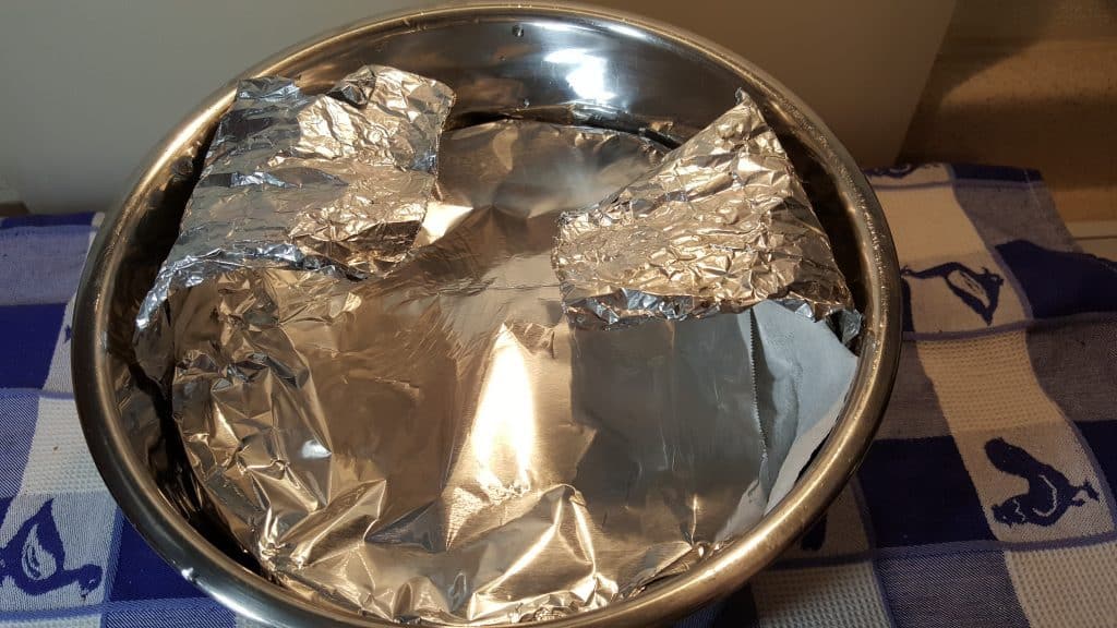 Using a foil sling, lower the pan into the Pressure Cooker