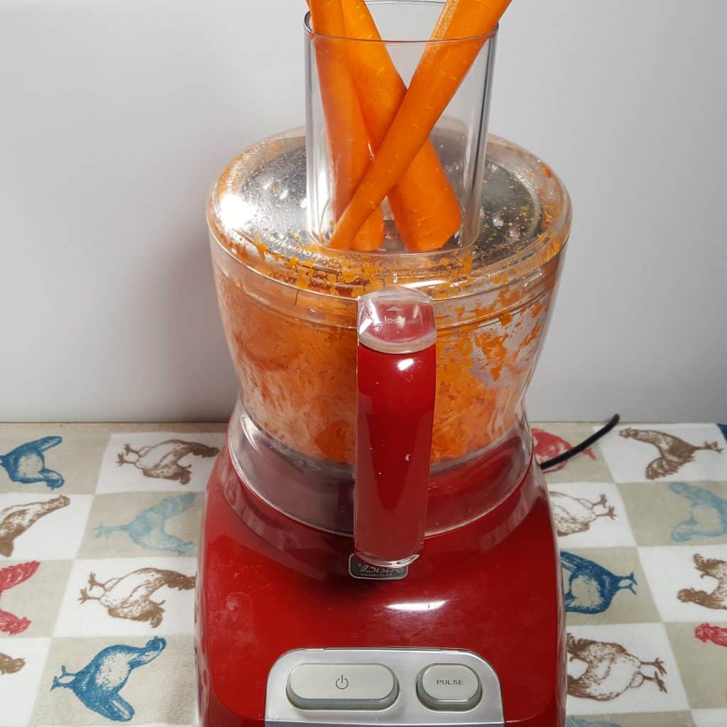 carrots being grated in a food processor
