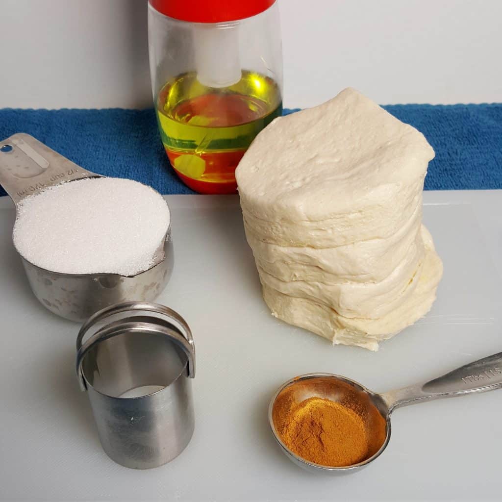 Ingredients, refrigerator biscuits, cinnamon, sugar, biscuit cutter and oil mister