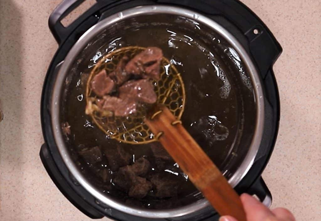 Remove the meat from cooking pot and place into barbecue sauce