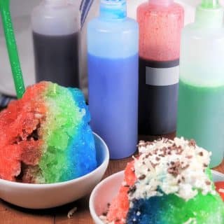 4 Bottles of Purple, Blue, Red and Green Sugar Free Shave Ice Syrup with two Shave Ice Cups in White Bowls